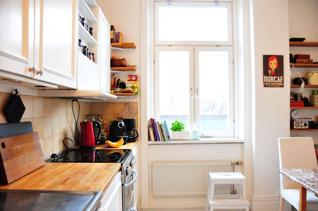 Bright kitchen with a wooden worktop beneath a tall window