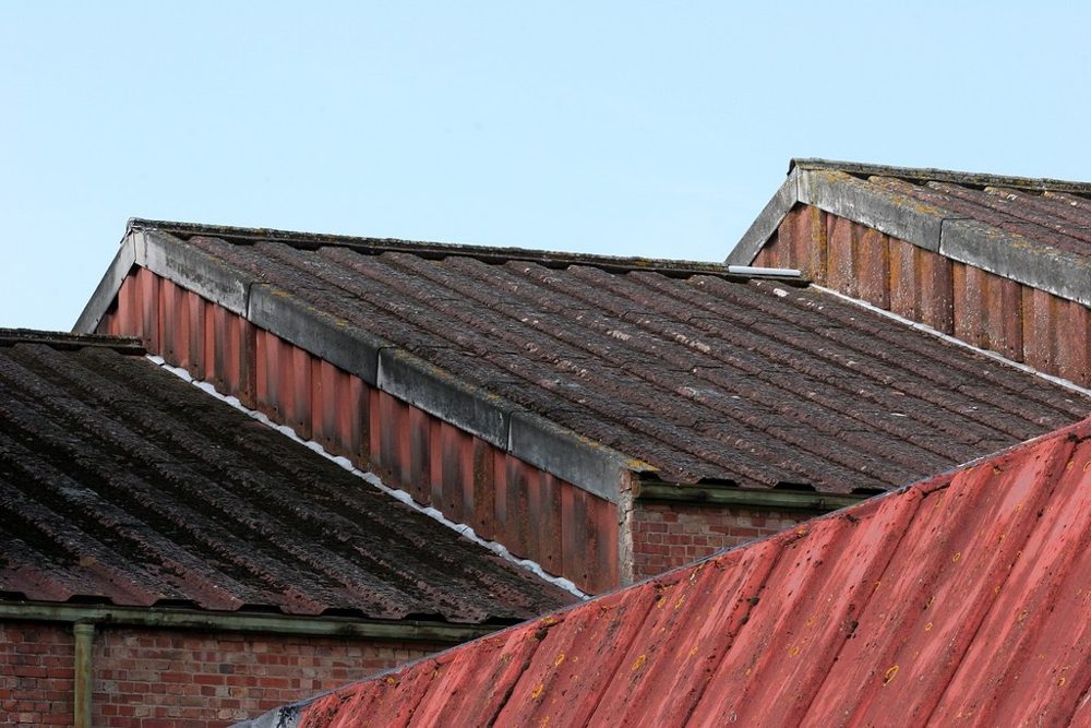 Weathered red and grey rooftops against a blue sky